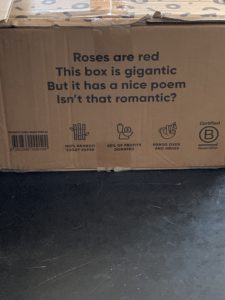 The packaging from Who Gives a Crap - cardboard box with writing on the side that reads "Roses are red, This Box is gigantic, But it has a nice poem, Isn't that romantic?"
